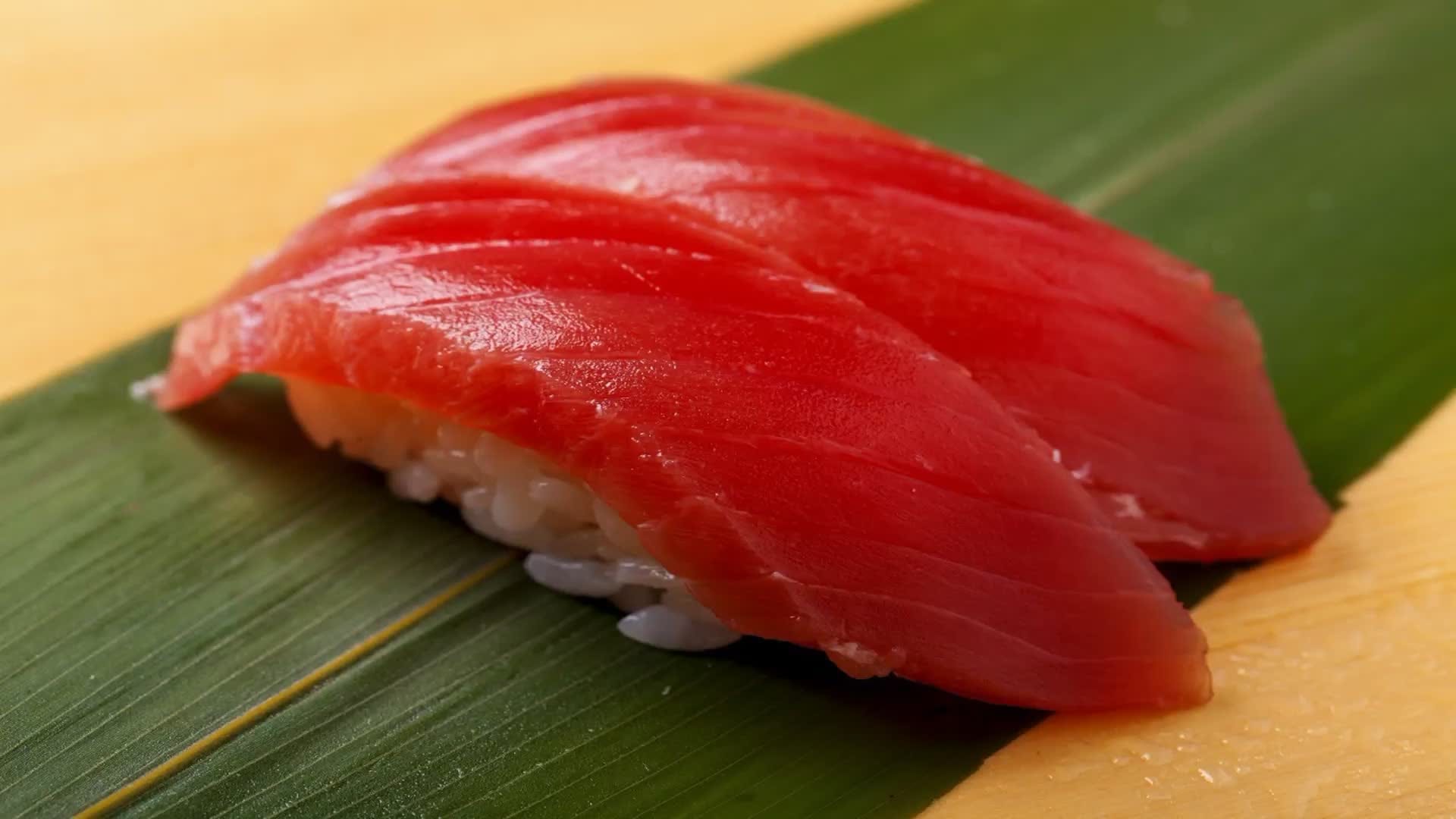 Akami maguro (lean tuna) nigiri served on a bamboo leaf at an edomae sushi counter in Tokyo